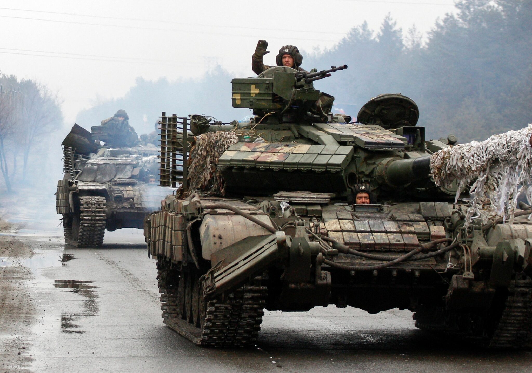 Ukrainian servicemen ride on tanks towards the front line with Russian forces in the Lugansk region of Ukraine on February 25, 2022. Ukrainian forces fought off Russian troops in the capital Kyiv on the second day of a conflict that has claimed dozens of lives, as the EU approved sanctions targeting President Vladimir Putin. Small arms fire and explosions were heard in the city's northern district of Obolonsky as what appeared to be an advance party of Russia's invasion force left a trail of destruction. (Photo by Anatolii STEPANOV / AFP)