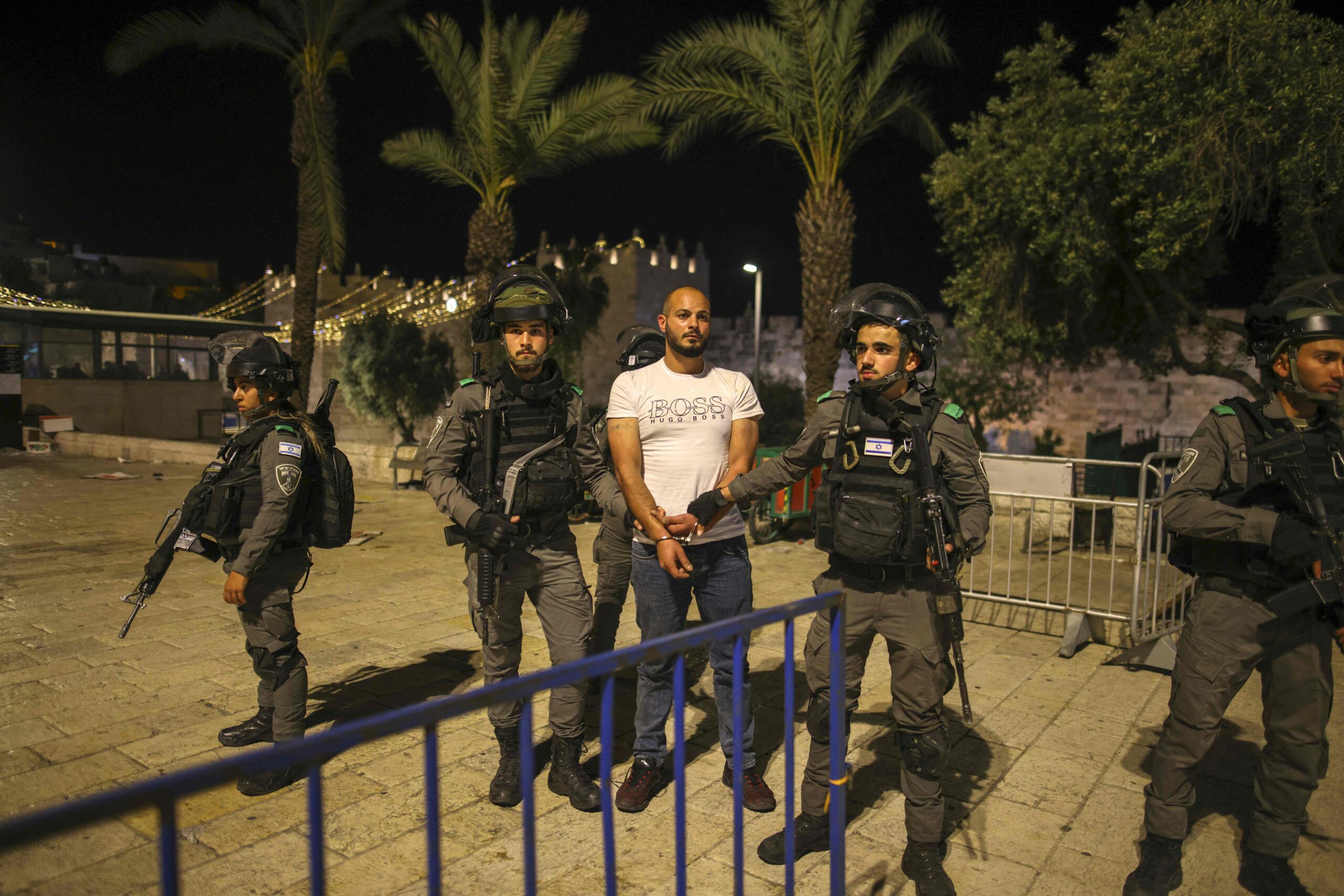 Israeli security forces detain a protester during clashes with Palestinian protesters outside the Damascus Gate in Jerusalem's Old City on April 23, 2021, amid mounting tensions over a ban on gatherings and anger fuelled by videos posted of attacks on youths. / AFP / AHMAD GHARABLI