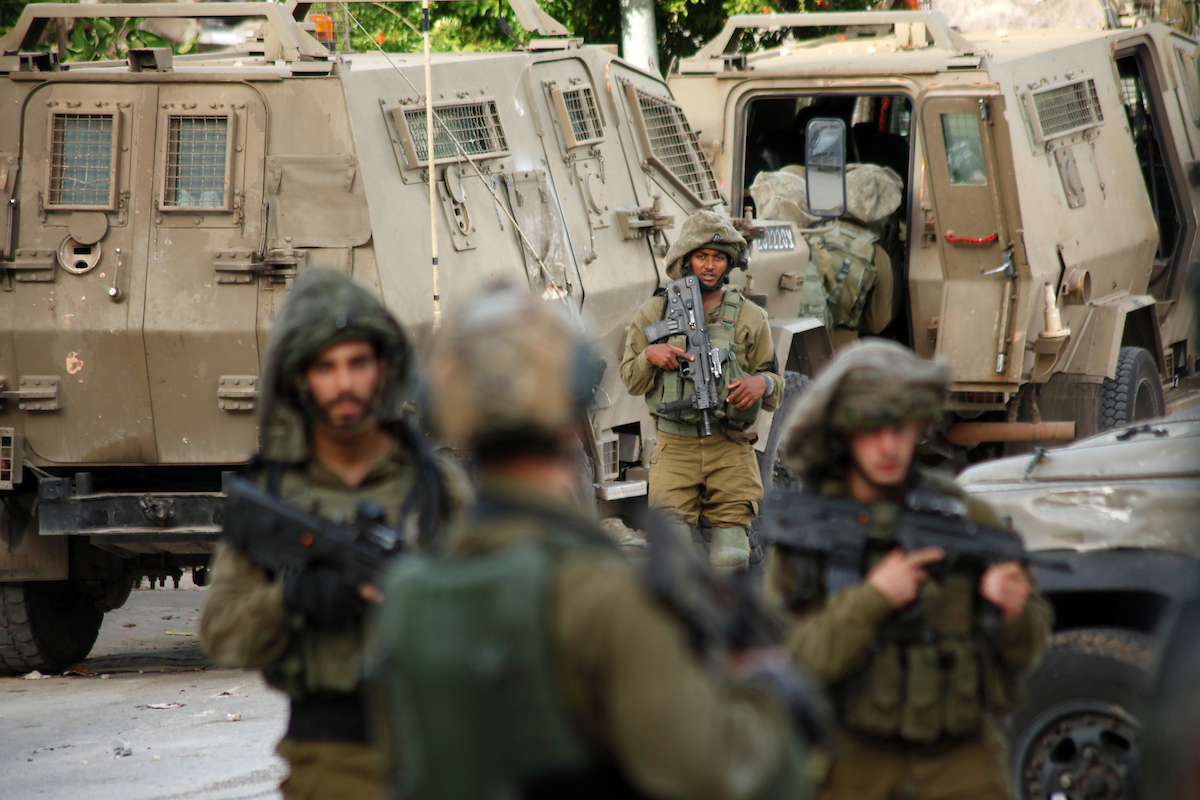 Israeli forces stand guard after an Israeli soldier was killed by a rock thrown during an arrest raid, in Yabad near the West Bank, city of Jenin, on May 13, 2020. Photo by Oday Daibes