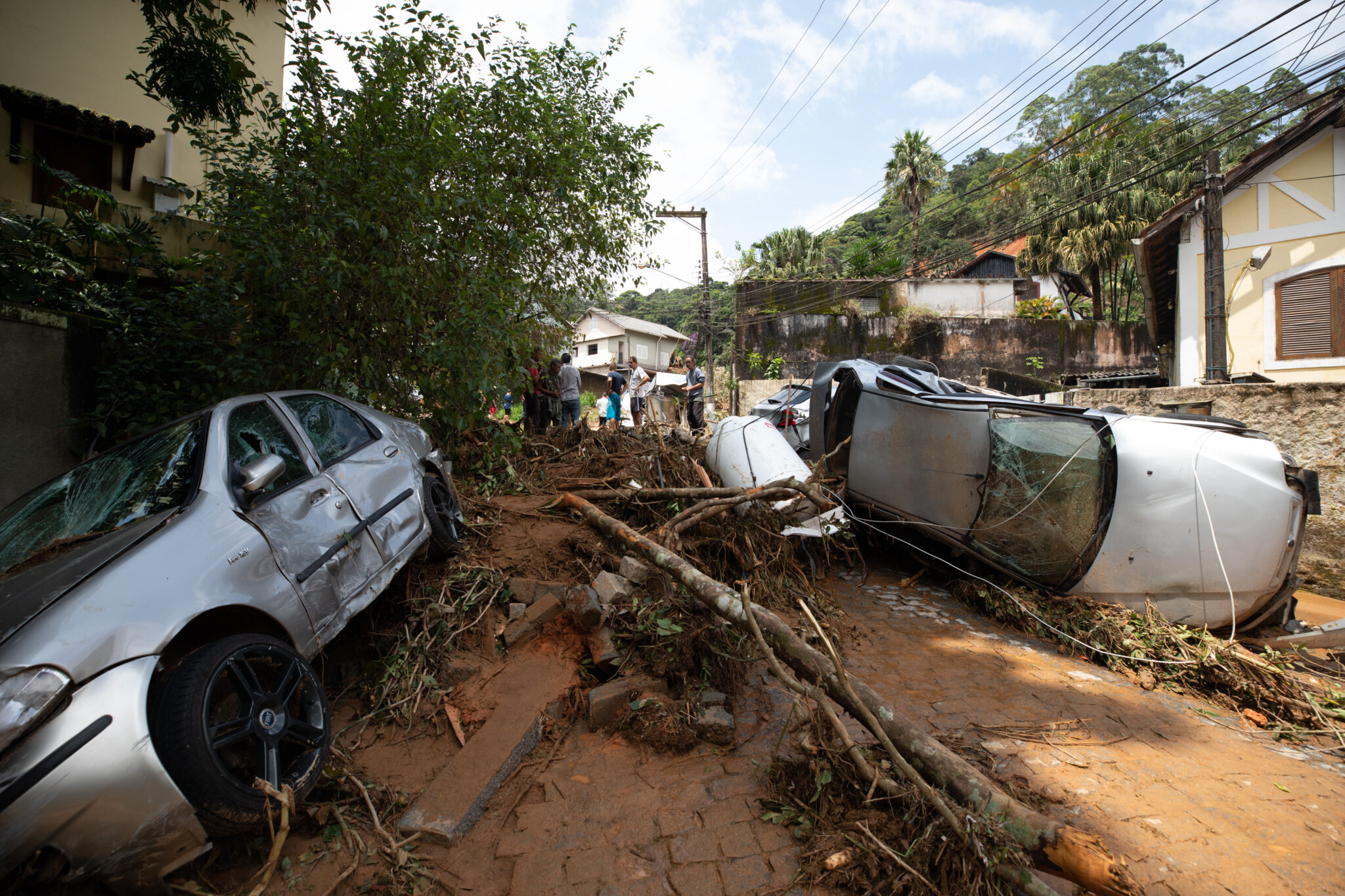 (220217) -- PETROPOLIS, Feb. 17, 2022 (Xinhua) -- Damaged trees and vehicles block a road after heavy rains in Petropolis in the state of Rio de Janeiro, Brazil, Feb. 16, 2022. The death toll from landslides and floods in the Brazilian city of Petropolis in Rio de Janeiro state rose to 78, including six children, local authorities said Wednesday. (Xinhua/Wang Tiancong)