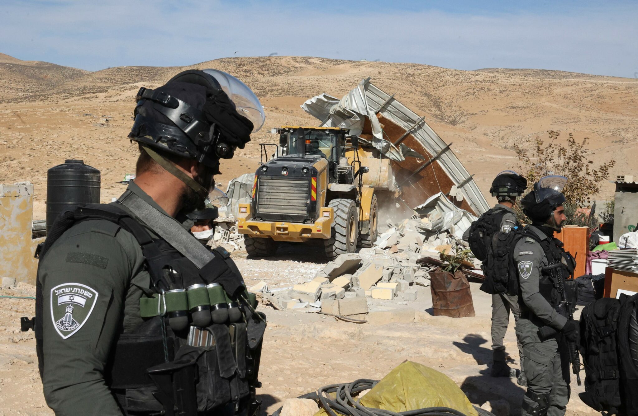 Israeli bulldozers demolish makeshift Palestinian houses in the village of al-Fikhit, south of Yatta in the southern area of the occupied west bank on January 12, 2022. (Photo by HAZEM BADER / AFP)