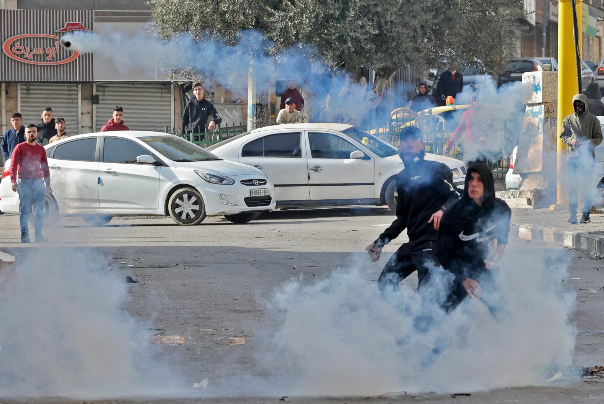 Palestinian demonstrators confront Israeli security forces following the Friday prayers, in the occupied West Bank town of Hebron, February 18,2022. (Photo by HAZEM BADER / AFP)