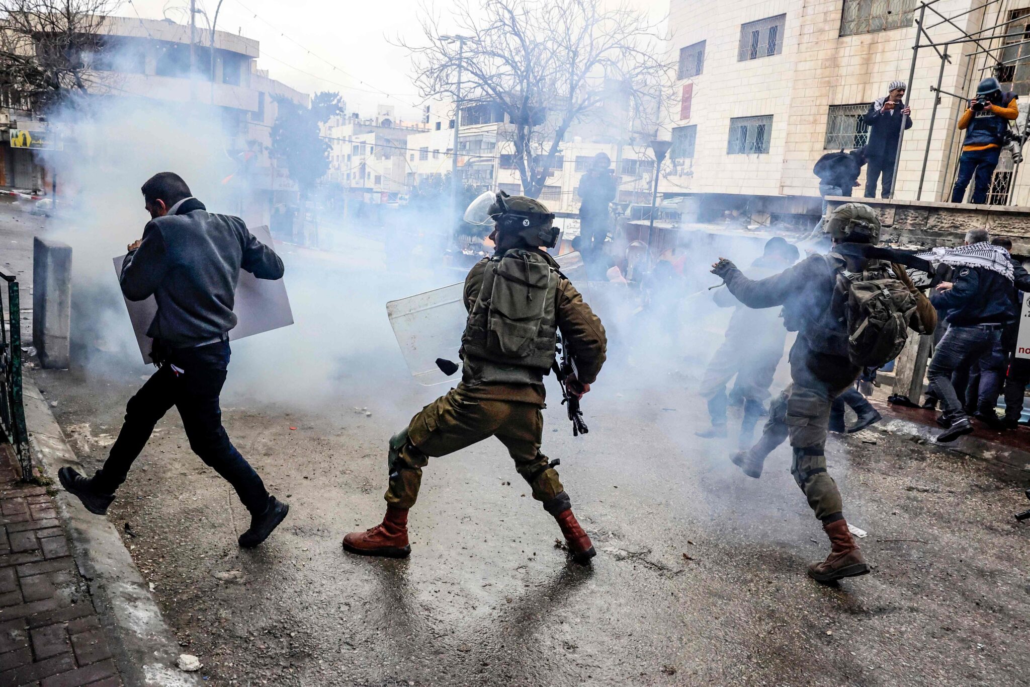 Members of the Israeli security forces chase a Palestinian protester during clashes following a demonstration to commemorate the 1994 Ibrahimi Mosque massacre, in the centre of the West Bank town of Hebron, on February 25, 2022. (Photo by HAZEM BADER / AFP)