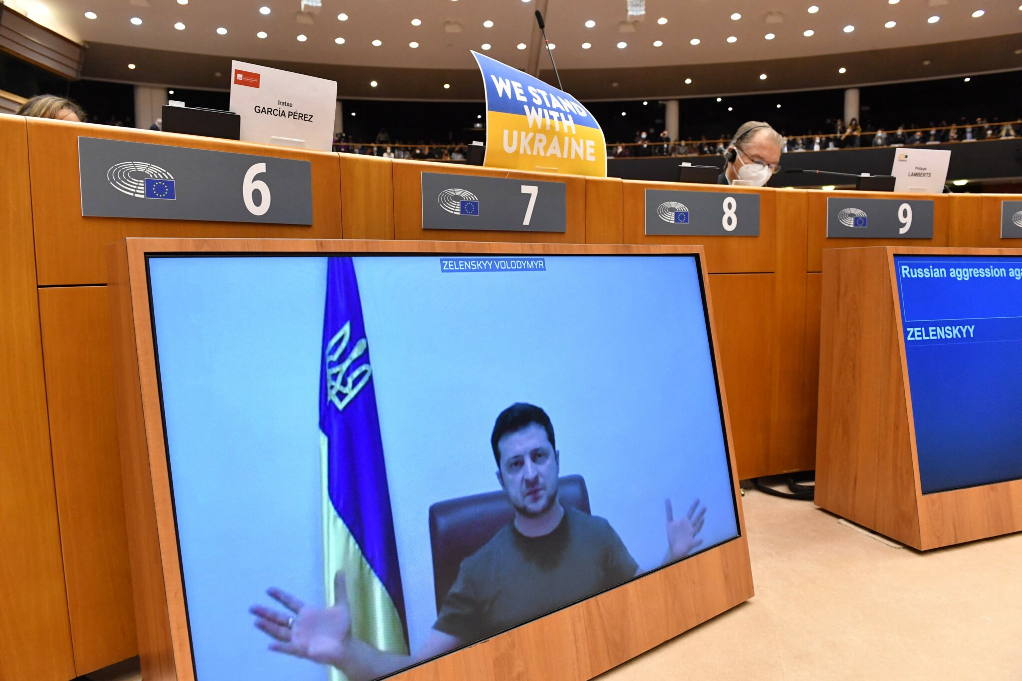 TOPSHOT - Ukrainian President Volodymyr Zelensky appears on a screen as he speaks in a video conference during a special plenary session of the European Parliament focused on the Russian invasion of Ukraine at the EU headquarters in Brussels, on March 01, 2022. The European Commission has opened the door for Ukraine to join the EU, but this is not for tomorrow, despite Kiev's request for a special procedure to integrate the country "without delay". (Photo by JOHN THYS / AFP)