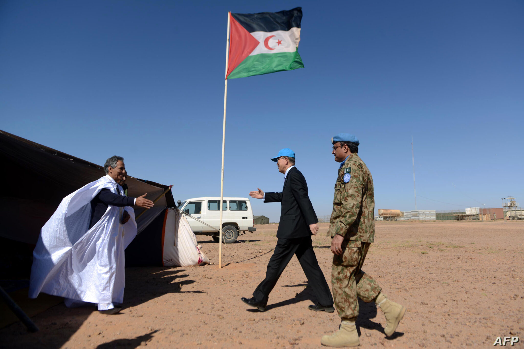 United Nations chief Ban Ki-moon (C) arrives for a meeting with Ahmed Boukhari (L), the Polisario Front's representative at the United Nations, on March 5, 2016, near a UN base in Bir-Lahlou, in the disputed territory of Western Sahara, situated 220 kilometres (137 miles) southwest of the Algerian town of Tindouf. / AFP / Farouk Batiche