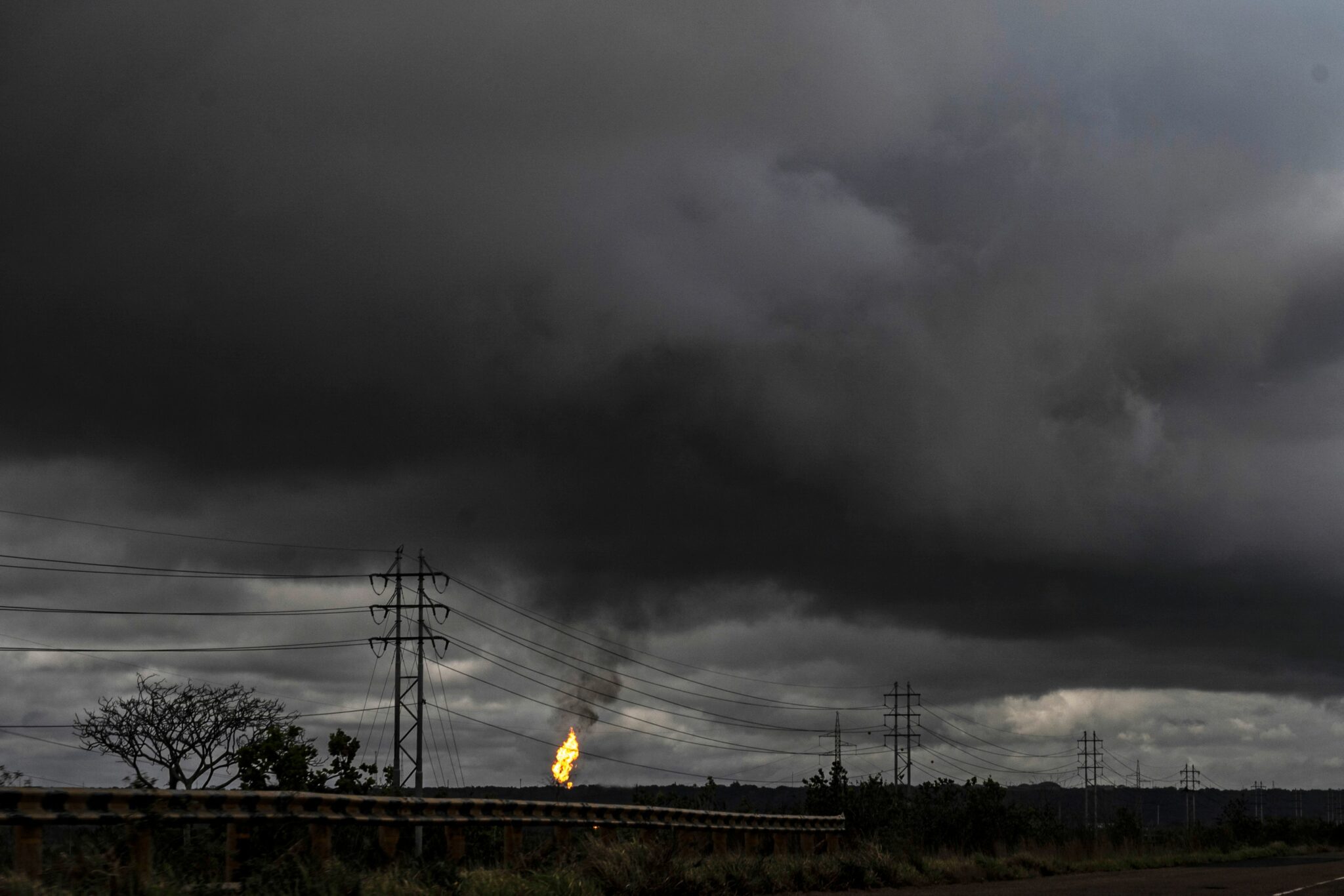 TOPSHOT - The flame from a chimney of an oil refining plant is seen along the highway between Puerto La Cruz and Maturin in Maturin, Venezuela, on March 2, 2022. The war in Ukraine and fears over the supply of raw materials from Russia pushed oil prices to a nearly 10-year high on Wednesday, while natural gas and aluminum hit all-time highs. (Photo by Yuri CORTEZ / AFP)