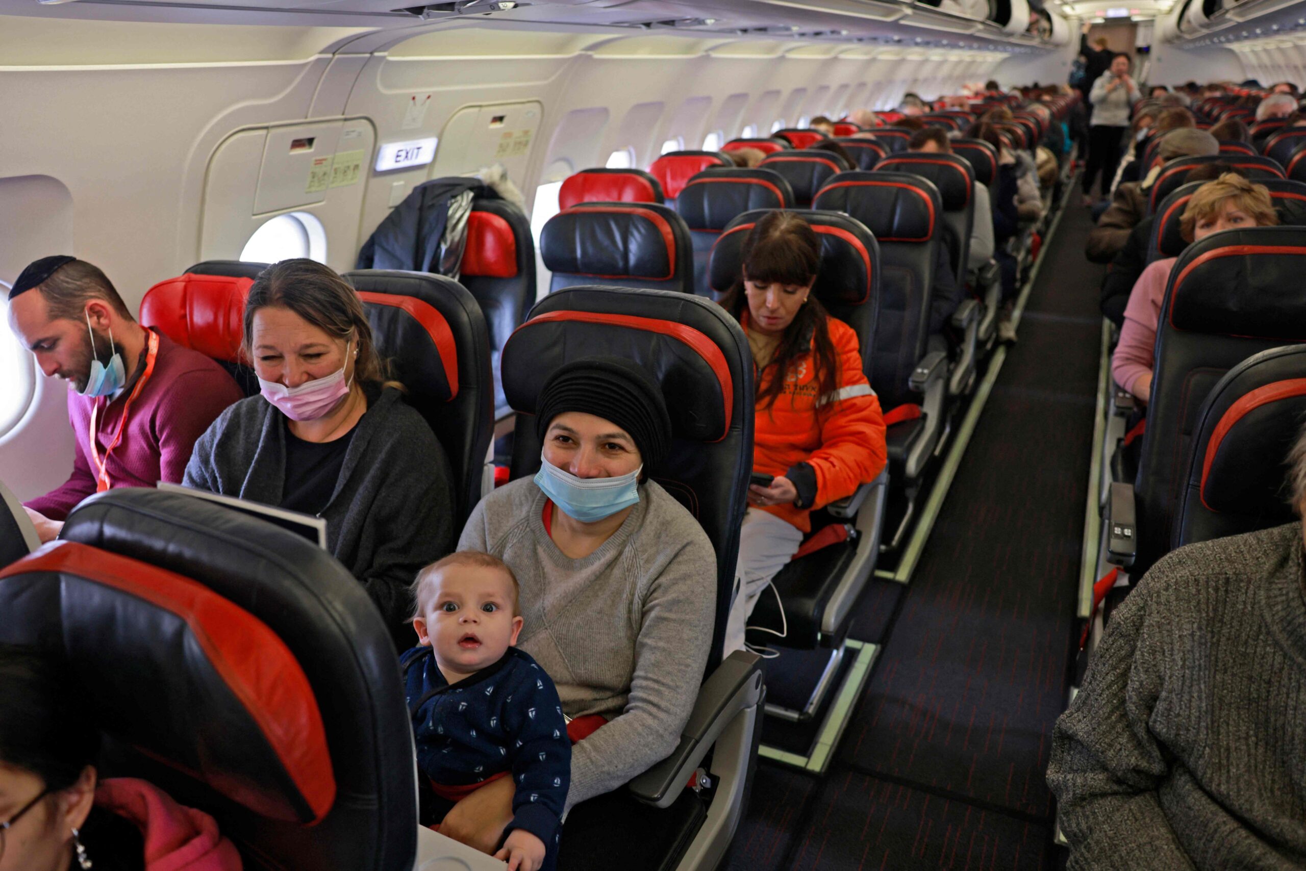 Ukrainian Jewish refugees are pictured in a plane headed to Israel from Kishinev airport in the Moldovan capital on March 10, 2022, after fleeing the war in their country. Some 150 Jews from Ukraine travelled to Israeli as part of a Aliya Immigration, with the help of United Hatzalah of Israel aid organisation. (Photo by MENAHEM KAHANA / AFP)