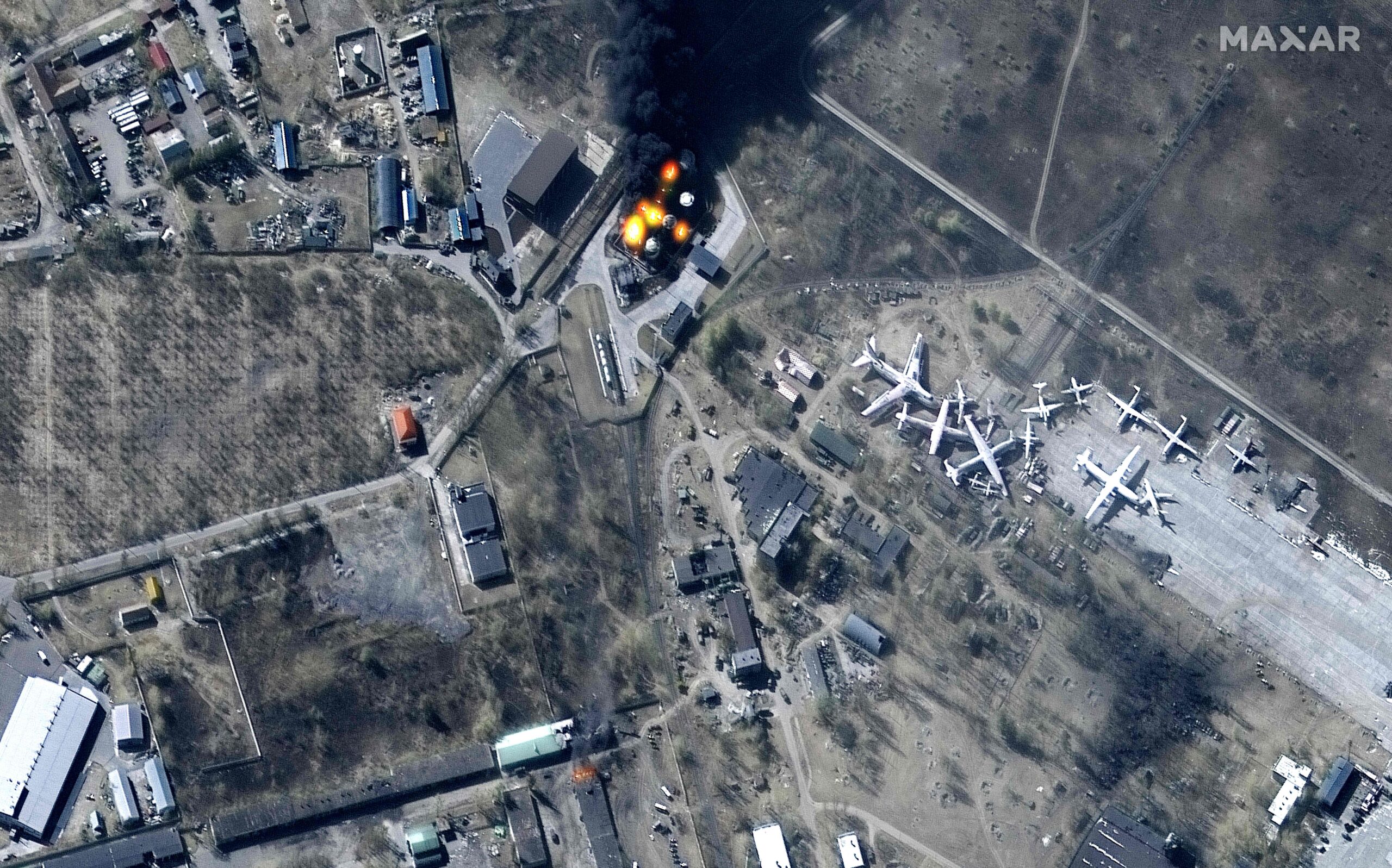 This Maxar satellite image taken and released on March 11, 2022 shows an overview of damaged buildings and burning fuel storage tanks at Antonov Airport in Hostomel, northwest of Kyiv. - RESTRICTED TO EDITORIAL USE - MANDATORY CREDIT "AFP PHOTO / Satellite image ©2022 Maxar Technologies " - NO MARKETING - NO ADVERTISING CAMPAIGNS - DISTRIBUTED AS A SERVICE TO CLIENTS - THE WATERMARK MAY NOT BE REMOVED/CROPPED (Photo by SATELLITE IMAGE ©2022 MAXAR TECHNOLOGIES / AFP) / RESTRICTED TO EDITORIAL USE - MANDATORY CREDIT "AFP PHOTO / Satellite image ©2022 Maxar Technologies " - NO MARKETING - NO ADVERTISING CAMPAIGNS - DISTRIBUTED AS A SERVICE TO CLIENTS - THE WATERMARK MAY NOT BE REMOVED/CROPPED