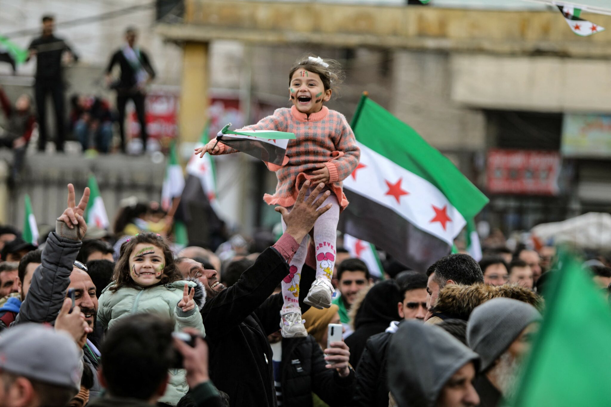 A child waves an opposition flag at a rally marking 11 years since the start of an anti-regime uprising, in the city of al-Bab in Syria's northern Aleppo governorate on March 18, 2022, marking 11 years since an anti-regime uprising. (Photo by Bakr ALKASEM / AFP)