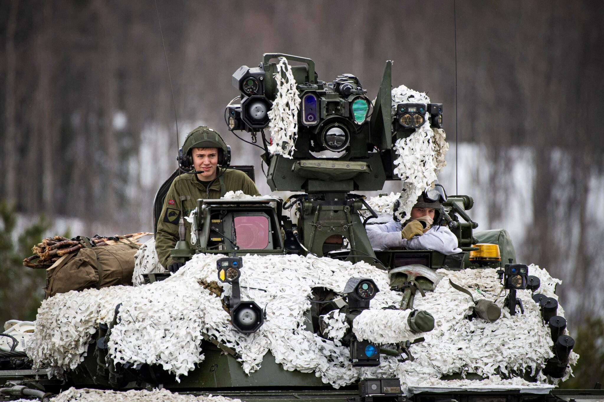 Soldiers from the Norwegian Armed Forces operate a tank as they participate in the international military exercise Cold Response 22, at Setermoen, North of in Norway, on March 22, 2022. Cold Response is a Norwegian-led winter exercise in which NATO and partner countries participate. 30,000 NATO troops are involved in the exercise that was planned long before Moscow's invasion of Ukraine. (Photo by Jonathan NACKSTRAND / AFP)