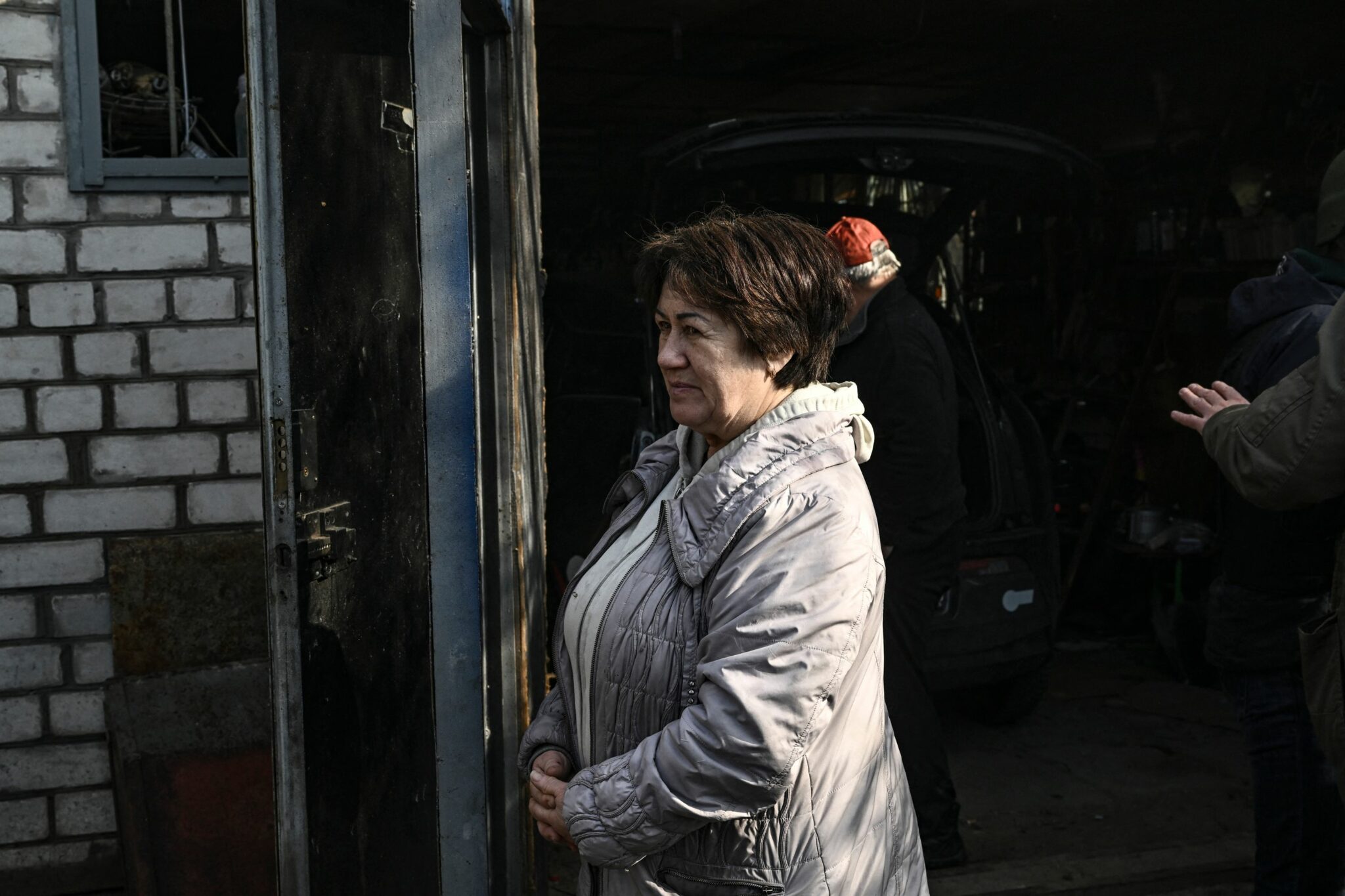 A woman looks at a burning house hit by Russian Grad rockets in Kyiv's Shevchenkivsky district, on March 22, 2022, as for the first time, there are signs that Ukrainian forces are going on the offensive, retaking a town near Kyiv and attacking Russian forces in the south of the country. Over 3.5 million Ukrainians have now fled the country following Russia's invasion, the United Nations says. More than 10 million have been displaced from their homes. (Photo by Aris Messinis / AFP)