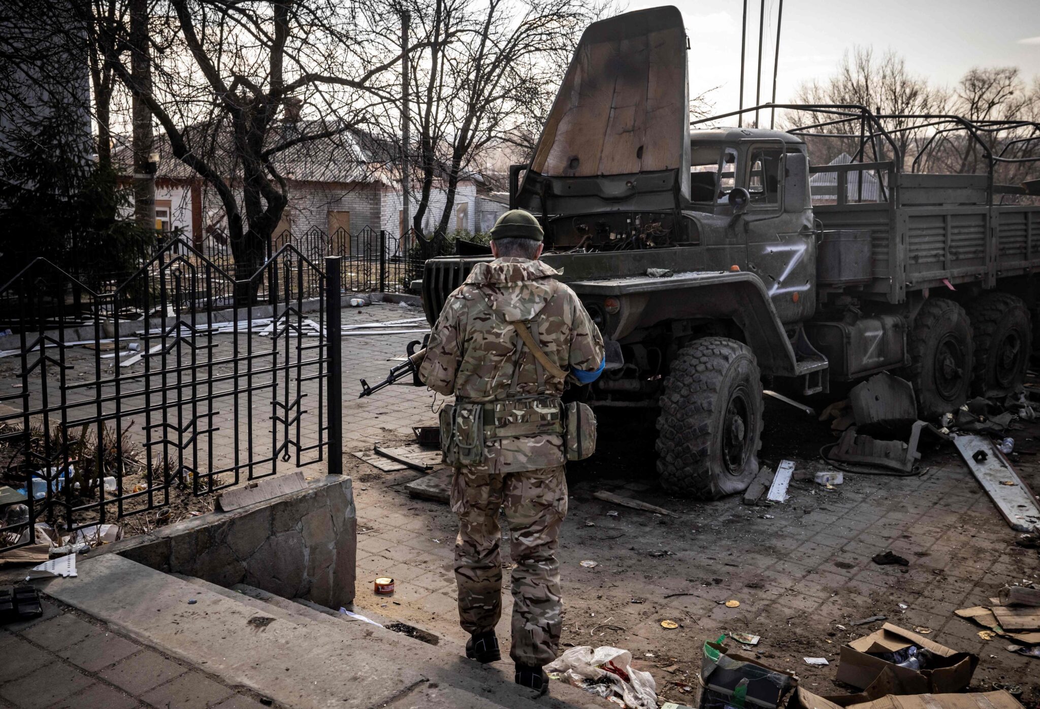 TOPSHOT - A Ukrainian serviceman stands near a Russian army truck in the northeastern city of Trostianets, on March 29, 2022. Ukraine said on March 26, 2022 its forces had recaptured the town of Trostianets, near the Russian border, one of the first towns to fall under Moscow's control in its month-long invasion. (Photo by FADEL SENNA / AFP)