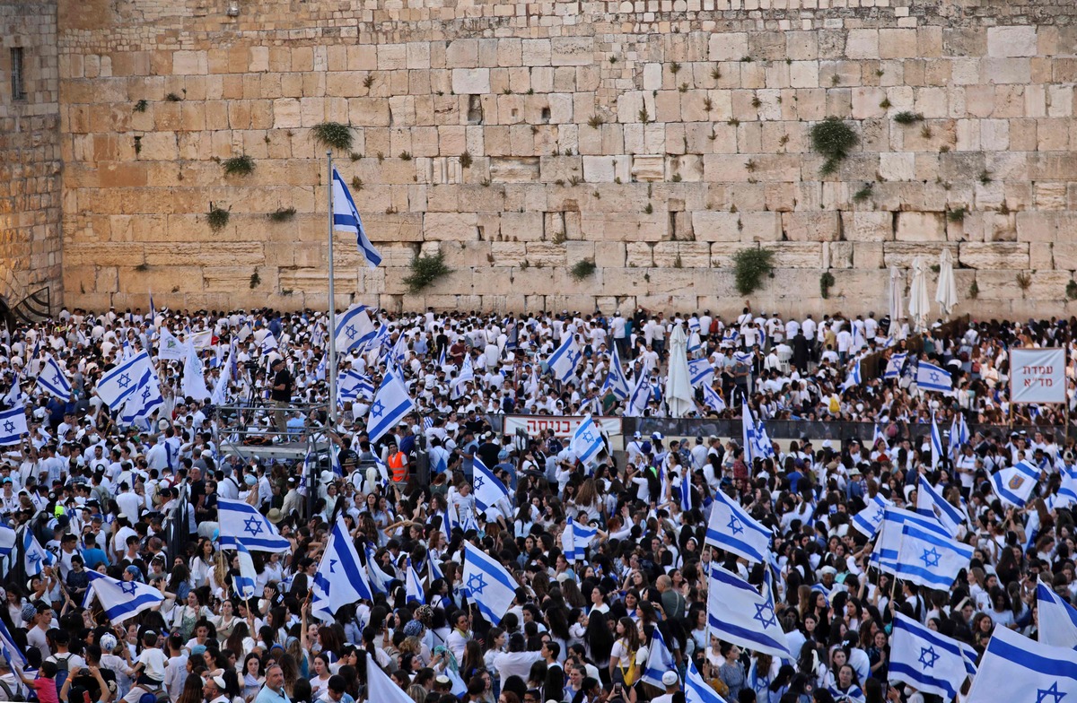 Demonstrators gather with Israeli flags at the Western Wall in the old city of Jerusalem on May 29, 2022, during the Israeli 'flags march' to mark "Jerusalem Day". Thousands of flag-waving Israelis marched on May 29 into the Muslim quarter of Jerusalem's Old City during a nationalist procession that regularly stokes Palestinian anger, a year after Jerusalem tensions exploded into war. (Photo by GIL COHEN-MAGEN / AFP)