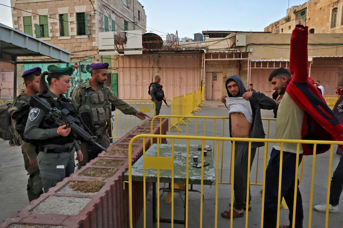 Israeli border police carry out security checks on Palestinians, as muslims gather to attend the morning Eid al-Fitr prayer, marking the end of the holy fasting month of Ramadan, outside the Ibrahimi Mosque or the Tomb of the Patriarchs in the old city of the occupied West Bank town of Hebron, on May 02, 2022. (Photo by HAZEM BADER / AFP)