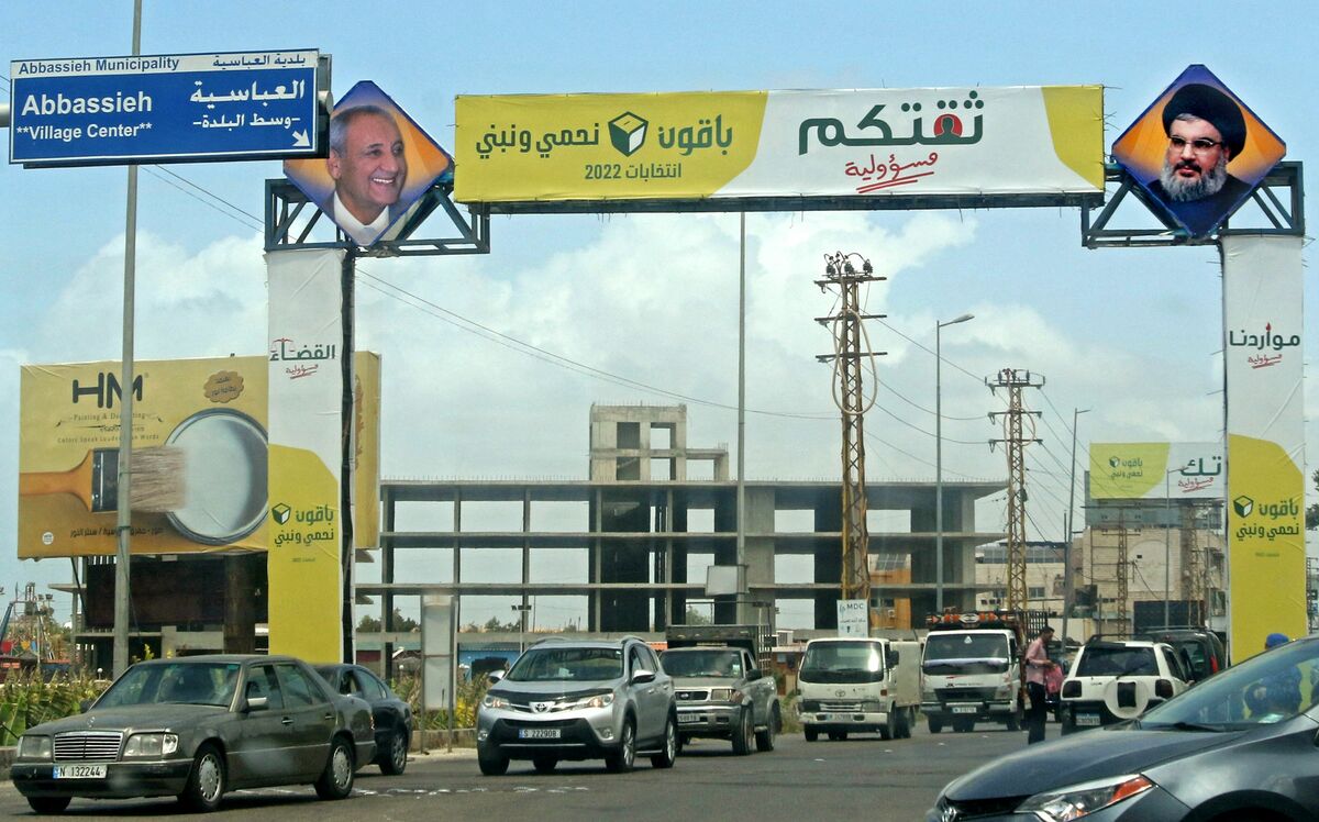 Cars drive beneath a Lebanese parliamentary election billboard for the Shiite Hezbollah group on a highway in the southern city of Tyre, on May 5, 2022. Lebanon's May 15 elections won't yield a seismic shift despite widespread discontent with a graft-tainted political class blamed for a painful economic crisis and a deadly disaster, experts say. (Photo by Mahmoud ZAYYAT / AFP)