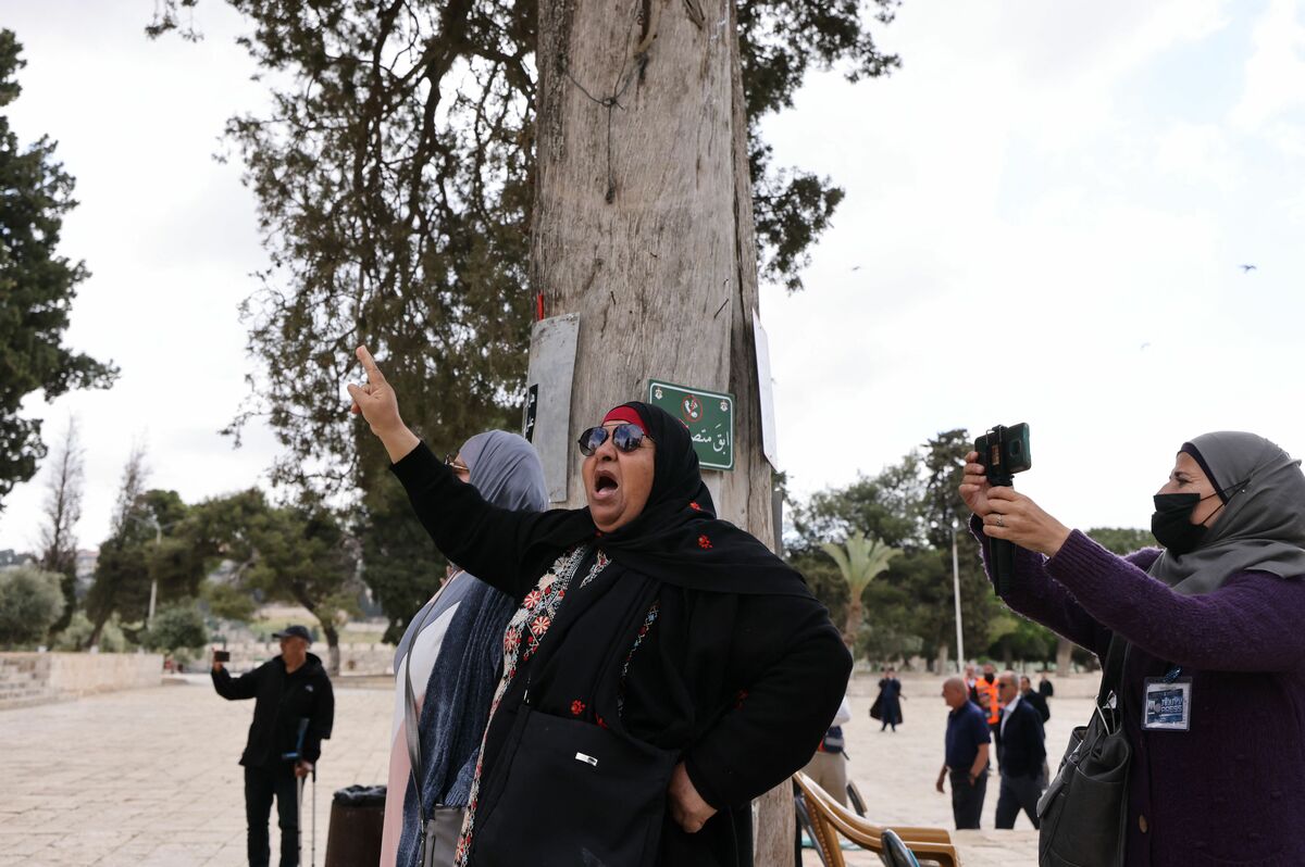 Palestinians protest as Israeli police (not in the picture) accompany a group of Jewish visitors past the Dome of the Rock mosque at the al-Aqsa mosque compound in the Old City of Jerusalem on May 5, 2022. Tourists and Jewish groups are allowed by Israeli police to enter the Al-Aqsa mosque compound for few a hours per day. The compound is revered as the site of two ancient Jewish temples, and home to al-Aqsa Mosque, Islam's third holiest site. Jews are allowed to enter the mosque compound but not to pray there. (Photo by AHMAD GHARABLI / AFP)