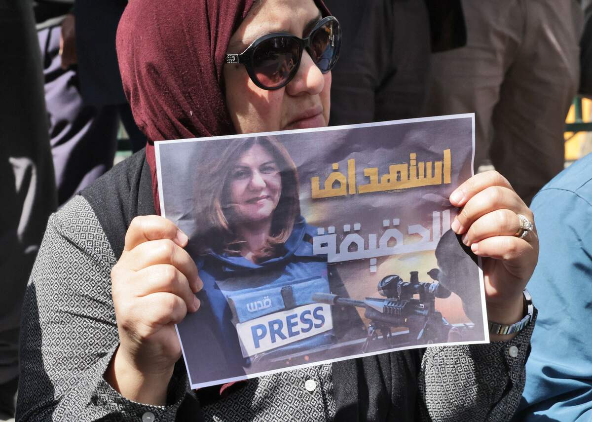 Palestinians hold posters displaying veteran Al Jazeera journalist Shireen Abu Aqleh, who was, according to the network, shot dead by Israeli troops as she covered a raid on the West Bank's Jenin refugee camp on May 11, 2022, in the West Bank city of Hebron. (Photo by HAZEM BADER / AFP)