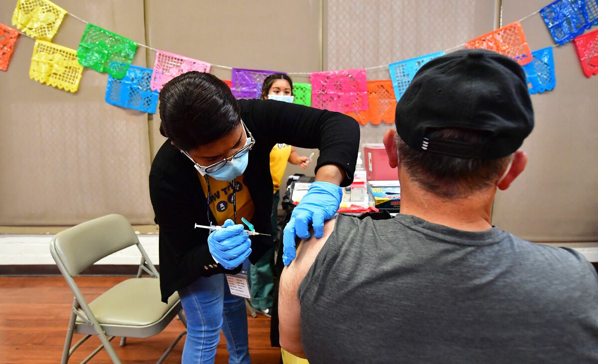 Registered Nurse Mariam Salaam administers the Pfizer booster shot at a Covid vaccination and testing site decorated for Cinco de Mayo at Ted Watkins Park in Los Angeles on May 5, 2022. Covid cases in Los Angeles County have topped 3,000 for the first time since mid-February with cases up nearly 300 percent in the past month, sparking concern of a potential "sixth wave" pandemic in the US. (Photo by Frederic J. BROWN / AFP)