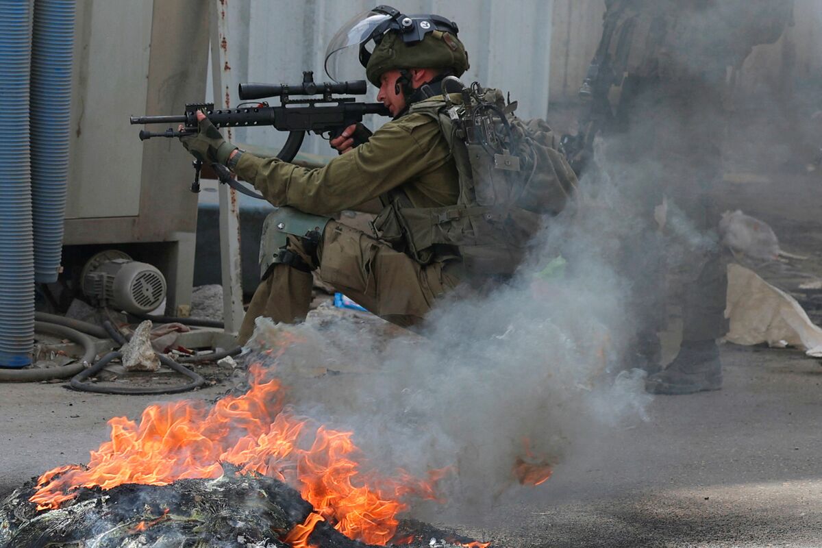 An Israeli soldier take positions during clashes with Palestinian in village of Azzun in the north of the occupied West Bank after the funeral of Yahya Edwan, who was killed during an overnight An Israeli army operation, on April 30, 2022. Israeli forces killed a Palestinian man overnight in the north of the occupied West Bank, according to the Palestinian health ministry, which added that the man, in his 20s, was shot in the chest during an Israeli army operation in the town of Azzun. (Photo by JAAFAR ASHTIYEH / AFP)