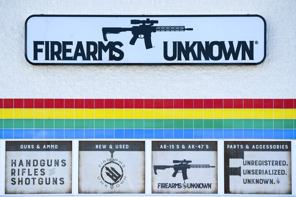 The silhouette AR-15 style rifle is displayed on signage for the Firearms Unknown Guns & Ammo gun store, in Yuma, Arizona on June 2, 2022. US President Joe Biden on June 2, 2022 urged lawmakers to ban privately owned assault weapons and high capacity magazines in order to curb the mass shootings plaguing the country. (Photo by Patrick T. FALLON / AFP)