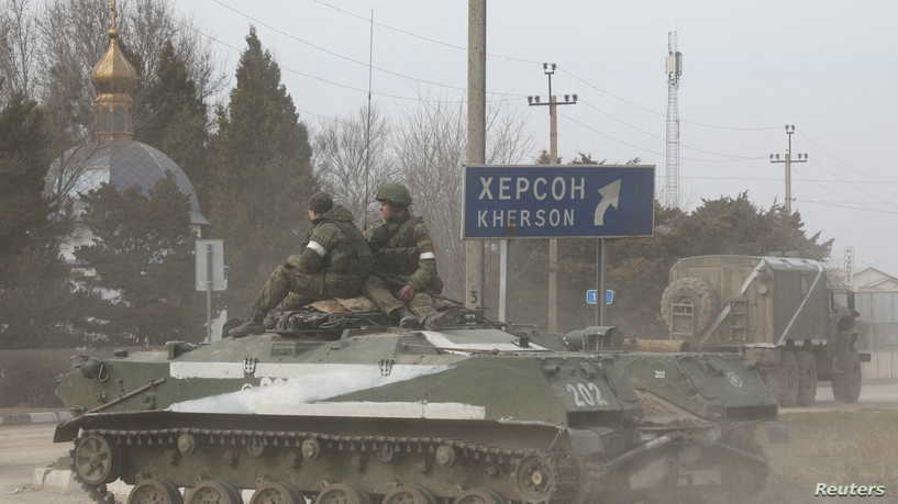 Servicemen ride on a Russian Army military armoured vehicle with the letter 'Z' on it, after Russian President Vladimir Putin authorized a military operation in eastern Ukraine, in the town of Armyansk, Crimea, February 24, 2022. REUTERS/Stringer