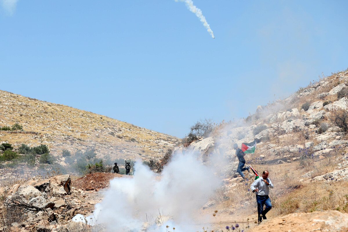 (220610) -- NABLUS, June 10, 2022 (Xinhua) -- Palestinian protesters run to take cover during clashes with Israeli soldiers following a protest against the expansion of Jewish settlements in the West Bank village of Beit Dajan, east of Nablus, on June 10, 2022. (Photo by Ayman Nobani/Xinhua)