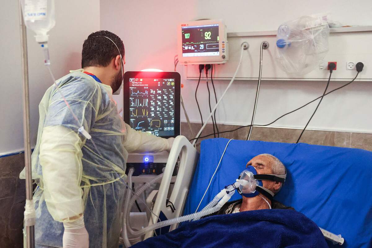 A medical worker monitors the vitals of an intubated patient at the COVID-19 coronavirus ward of Dura Governmental Hospital in the town of Dura on the outskirts of Hebron in the occupied West Bank on February 5, 2022. (Photo by HAZEM BADER / AFP)