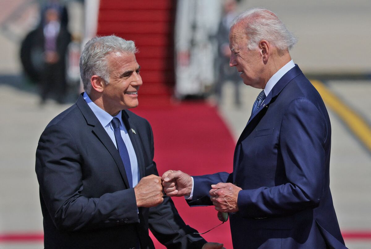 US President Joe Biden (R) bumps fists with Israel's caretaker Prime Minister Yair Lapid following his arrival at Ben Gurion Airport in Lod near Tel Aviv, on July 13, 2022. (Photo by JACK GUEZ / AFP)