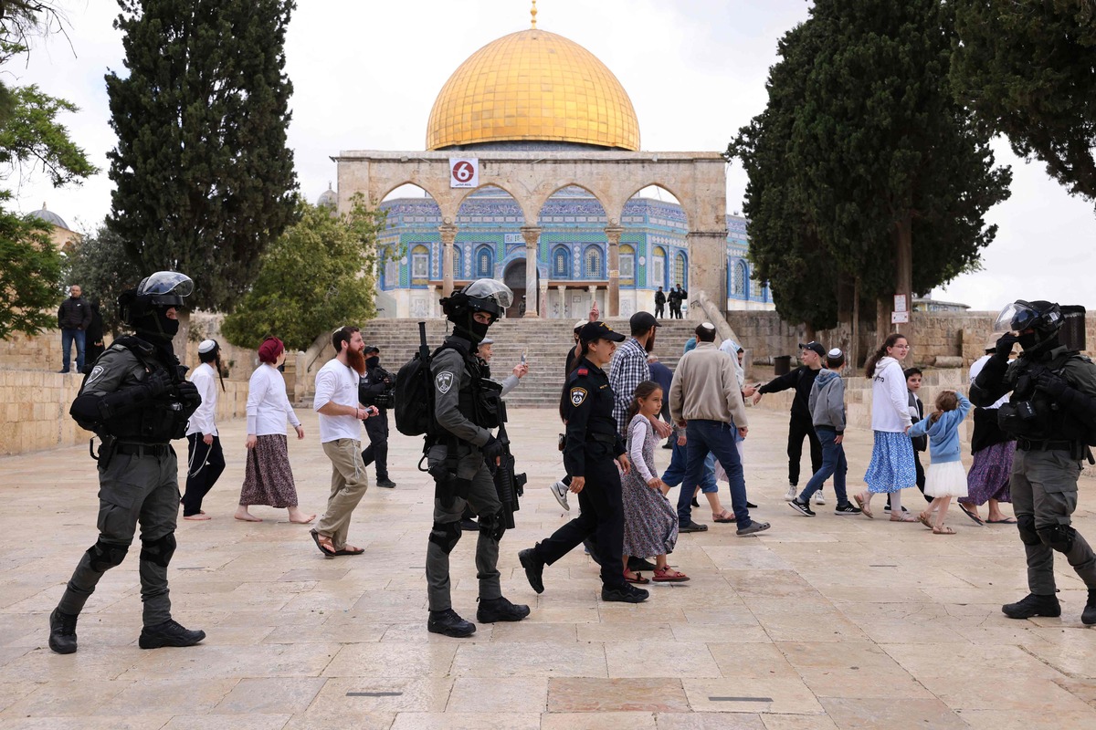 Israeli police accompany a group of Jewish visitors past the Dome of the Rock mosque at the al-Aqsa mosque compound in the Old City of Jerusalem on May 5, 2022. Tourists and Jewish groups are allowed by Israeli police to enter the Al-Aqsa mosque compound for few a hours per day. The compound is revered as the site of two ancient Jewish temples, and home to al-Aqsa Mosque, Islam's third holiest site. Jews are allowed to enter the mosque compound but not to pray there. (Photo by AHMAD GHARABLI / AFP)