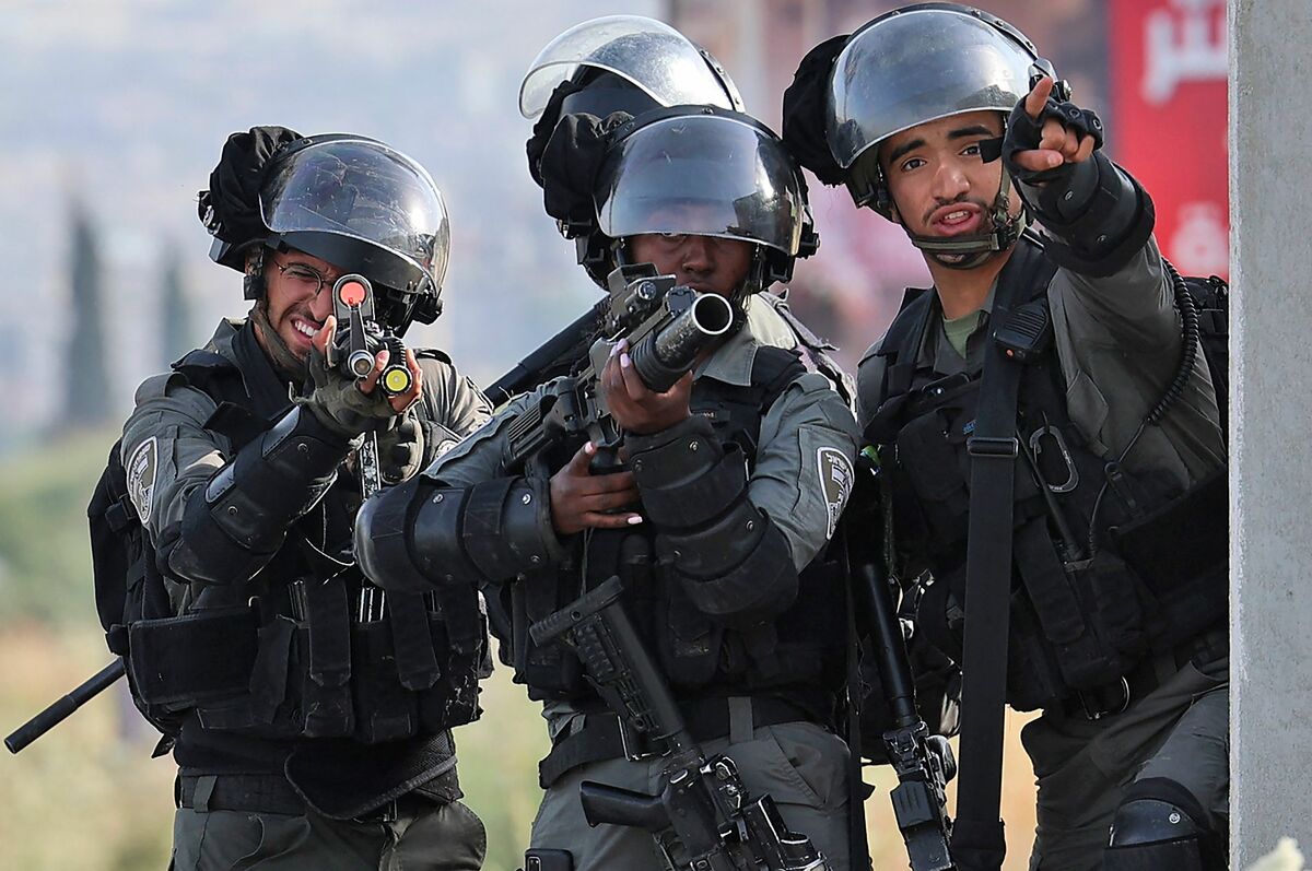 Israeli border guards take aim during clashes with Palestinian protesters following a demonstration to denounce the annual nationalist "flag march" through Jerusalem, at the Israeli-controlled Hawara checkpoint near Nablus in the occupied West Bank on May 29, 2022. Thousands of Israelis started the annual nationalist "flag march" through Jerusalem that regularly stokes Palestinian anger, a year after tensions in the disputed Holy City exploded into war. Some 3,000 police were deployed for the event that marks Israel's 1967 capture of east Jerusalem, home of the Al-Aqsa mosque compound located on what Jews revere as the Temple Mount. (Photo by JAAFAR ASHTIYEH / AFP)