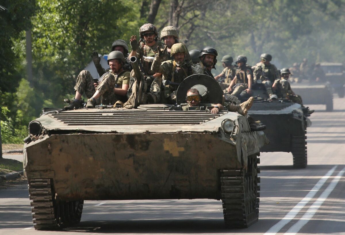 Ukrainian servicemen sit on infantry fighting vehicles driving down a road in the Donetsk region on August 18, 2022, amid the Russian invasion of Ukraine. (Photo by Anatolii Stepanov / AFP)