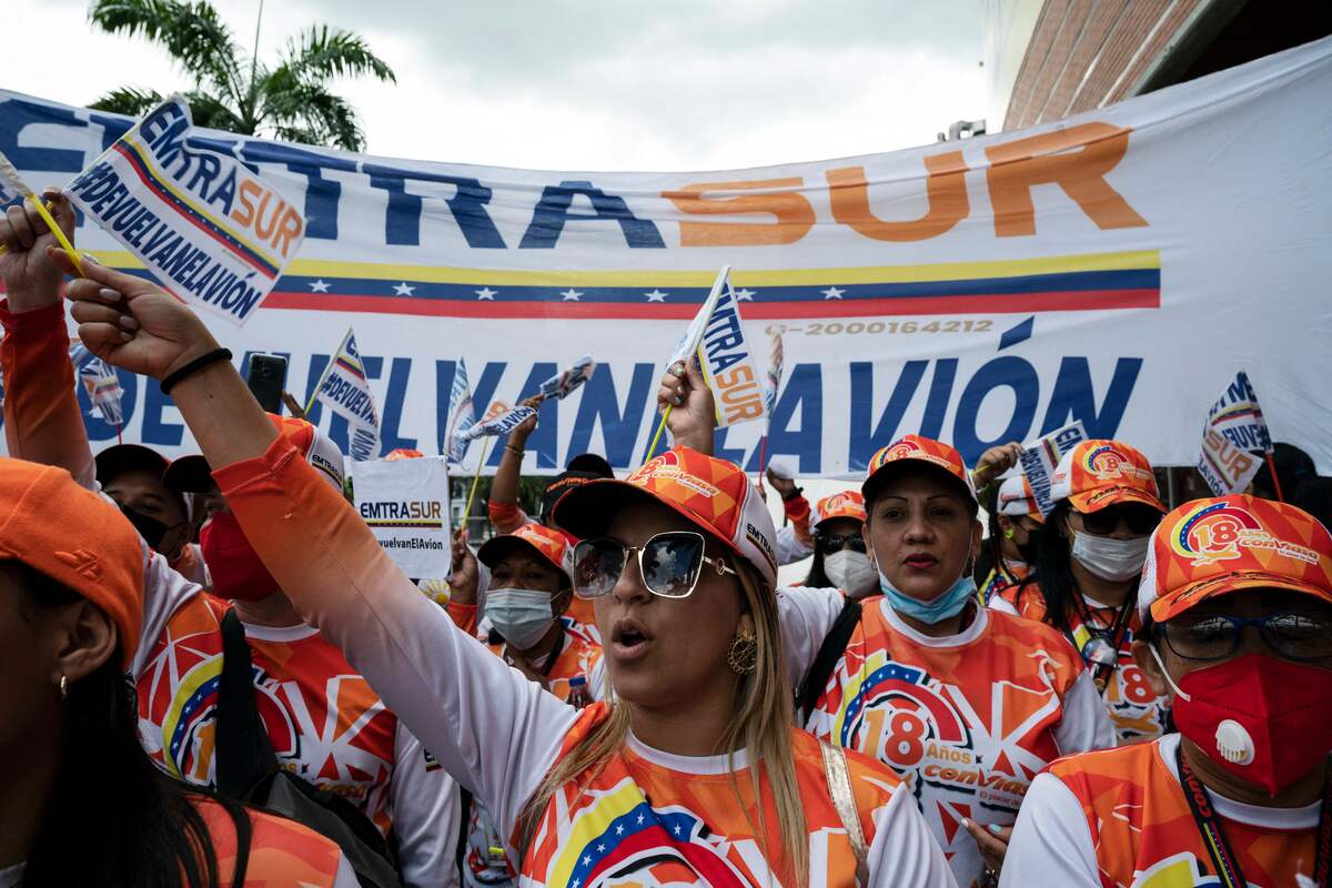 Workers of the Venezuelan airline CONVIASA protest in front of the Argentine embassy in Caracas demanding the return of an EMTRASUR cargo plane and its crew that were held in Argentina on June 8 under investigation, in Caracas, on August 11, 2022. The aircraft was seized on June 8 by order of a court, which then opened an investigation against the crew, made up of 14 Venezuelans and five Iranians. Last week, the judge handling the case allowed the departure of 12 of the crew. (Photo by Yuri CORTEZ / AFP)