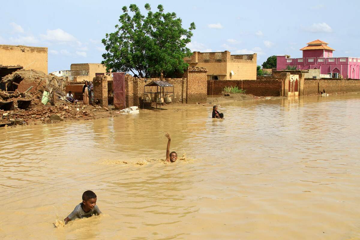 Sudanese children swim in flood water in the town of Iboud, 250kms south of the capital Khartoum, on August 22, 2022. (Photo by Ebrahim Hamid / AFP)