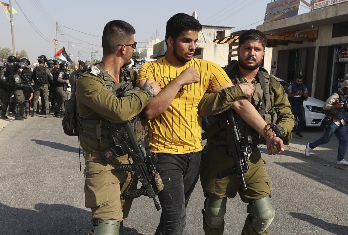 Israeli security forces detain a Palestinian protester during a rally against Israeli settlements on August 30 2022, east of Qalqilia, in the Israeli occupied West Bank. (Photo by JAAFAR ASHTIYEH / AFP)