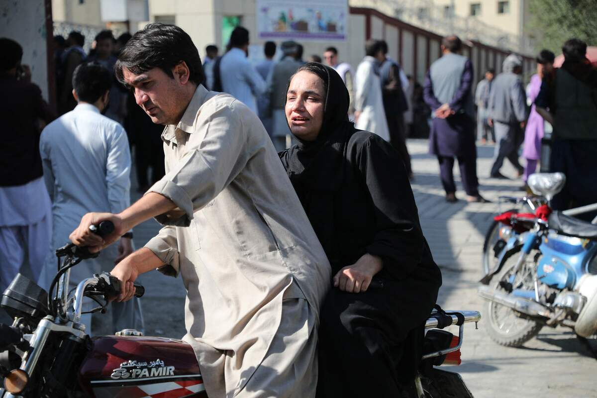 A woman arrives on a motorbike to search for a relative at a hospital in Kabul on September 30, 2022 after a blast in a learning centre in the Dasht-e-Barchi area of Afghanistan's capital. A suicide bombing at a learning centre in the Afghan capital Kabul killed at least 19 people on September 30 morning, police spokesman Khalid Zadran said. (Photo by AFP)