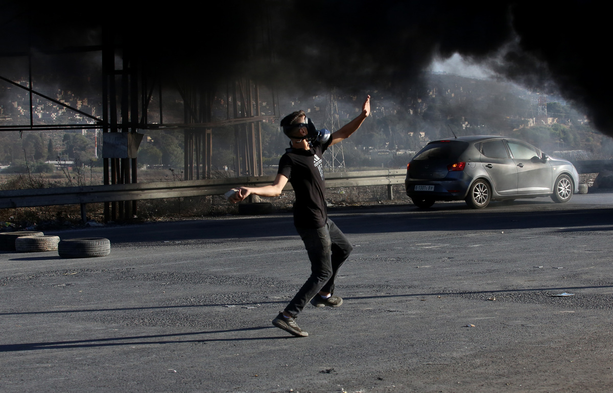 (220928) -- NABLUS, Sept. 28, 2022 (Xinhua) -- A Palestinian protester hurls a stone during clashes with Israeli soldiers following a protest at Hawara checkpoint near the West Bank city of Nablus, on Sept. 28, 2022. (Photo by Nidal Eshtayeh/Xinhua)