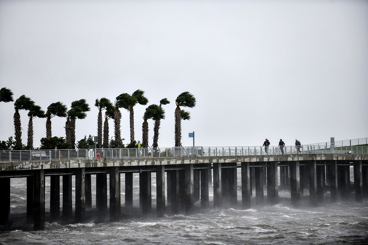 SAINT PETERSBURG, FLORIDA - SEPTEMBER 28: Local residents walk in the middle of rain and heavy wind at the St. Pete pier as the Hurricane Ian hits the west coast on September 28, 2022 in St. Petersburg, Florida. Ian is hitting the area as a likely Category 4 hurricane. Gerardo Mora/Getty Images/AFP