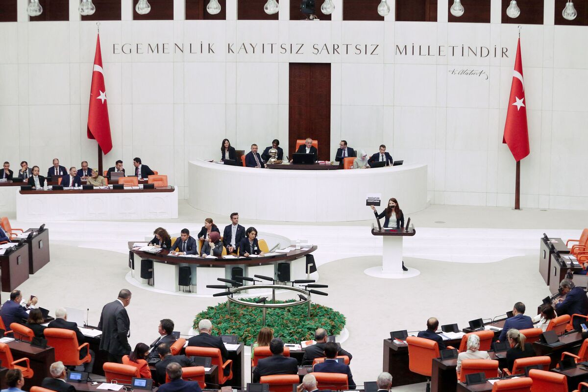 Peoples' Democratic Party's Zuleyha Gulum holds a banner "Truths cannot be obscured" as she stands with a covered mouth at the Turkish Grand National Assembly in Ankara on October 13, 2022, in protest over a new media law that could leads up to three years of jail for spreading "fake news" by reporters and social networks users. (Photo by Adem ALTAN / AFP)