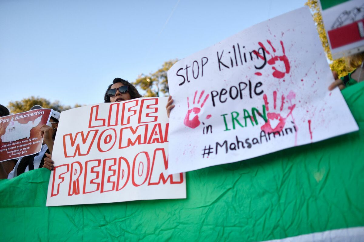 A woman holds a sign reading "Life, Woman, Freedom" during a demonstration in support of Iranian women on October 4, 2022 in Barcelona following the death of Kurdish Iranian woman Mahsa Amini in Iran. Amini, 22, died in custody on September 16, 2022, three days after her arrest by the notorious morality police in Tehran for allegedly breaching the Islamic republic's strict dress code for women. (Photo by Pau BARRENA / AFP)