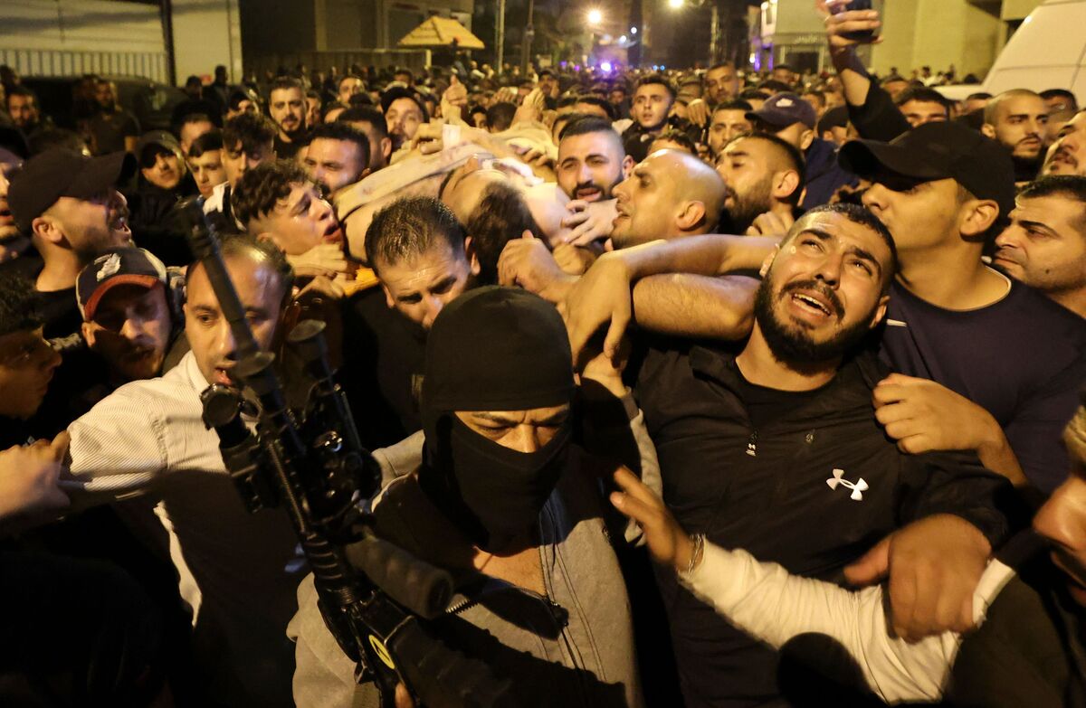 EDITORS NOTE: Graphic content / Men carry the body of the alleged Lion's Den leader from a hospital in Nablus after he was killed in a clash with Israeli soldiers, in the occupied West Bank on early October 25, 2022. Four Palestinians were killed and nearly 20 others injured early October 25, 2022 in a raid by Israeli forces in the occupied West Bank, the Palestinian Health Ministry said. (Photo by Jaafar ASHTIYEH / AFP)