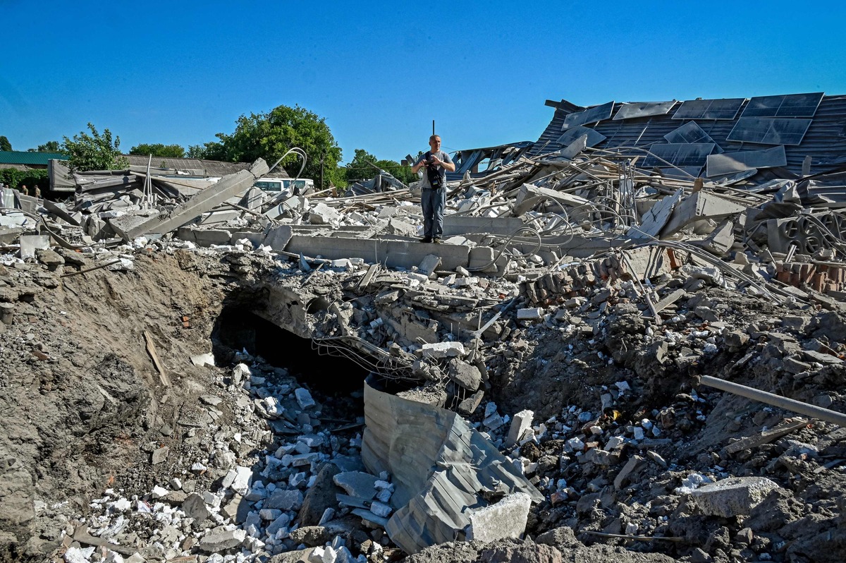 TOPSHOT - An official examines the ruins of a furniture factory following a missile strike on the second largest Ukrainian city of Kharkiv on August 6, 2022, as the Russia-Ukraine war enters its 163rd day. (Photo by SERGEY BOBOK / AFP)