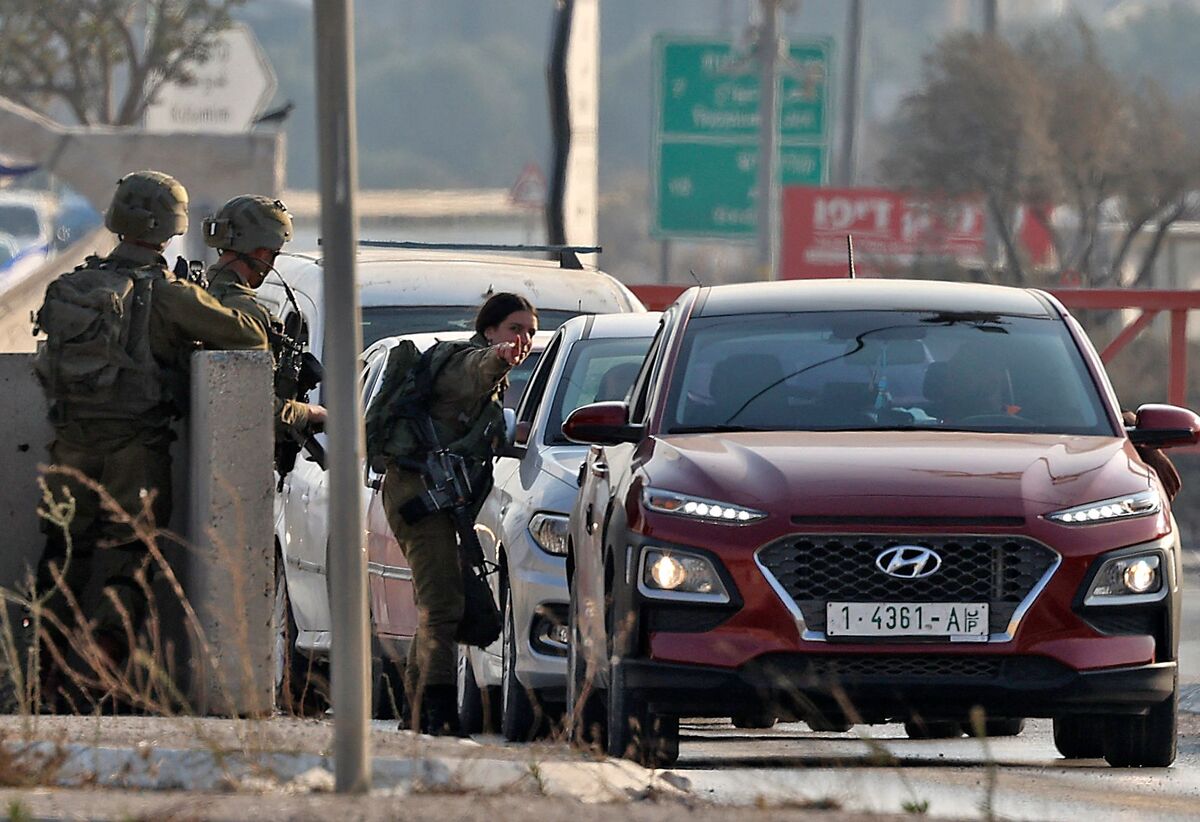 Members of the Israeli security forces check cars at the Huwara checkpoint near the West Bank city of Nablus on October 12, 2022, a day after an Israeli soldier was shot and killed near a settlement in an attack claimed by Palestinian militants. Violence has surged in recent months in the Israeli-Palestinian conflict, amid near daily West Bank raids and an uptick in attacks on Israeli troops. (Photo by JAAFAR ASHTIYEH / AFP)