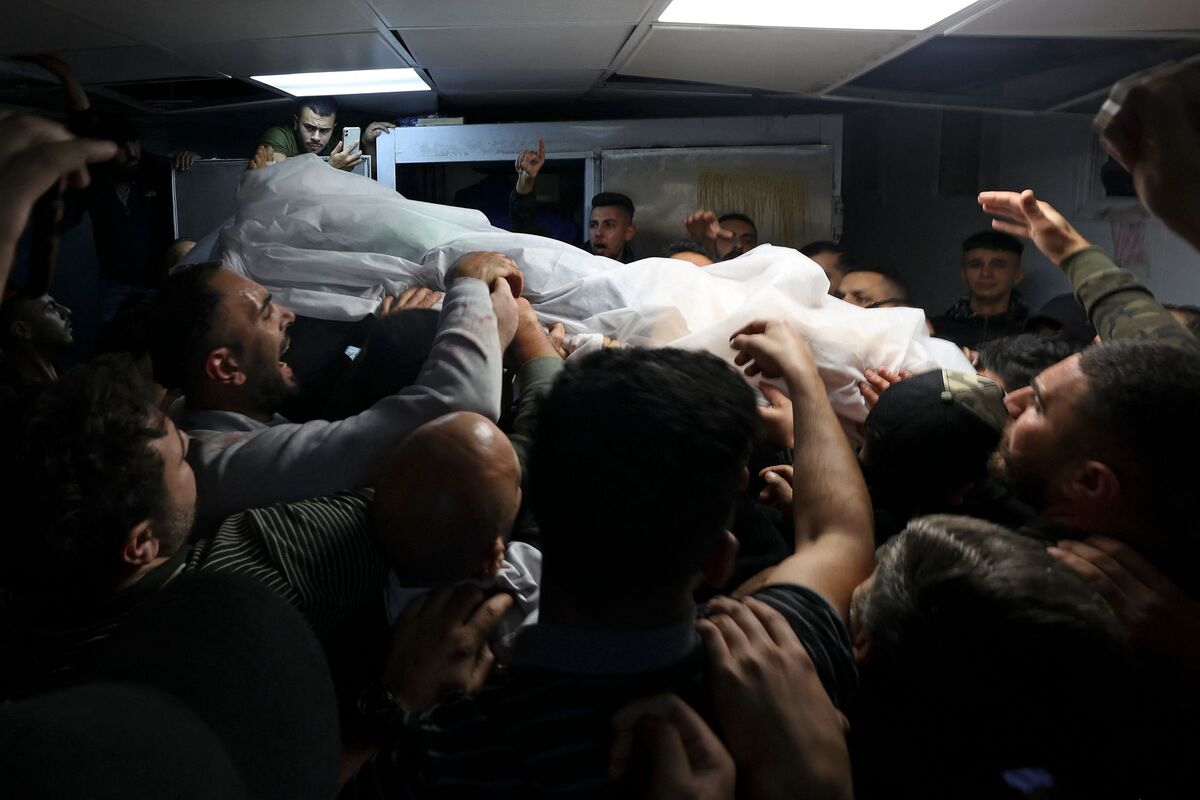 EDITORS NOTE: Graphic content / Men carry Hamdi Sharaf's body out of a morgue after clashing with Israeli forces in Nablus, in the occupied West Bank on early October 25, 2022. Three Palestinians were killed and nearly 20 others injured early October 25, 2022 in a raid by Israeli forces in the occupied West Bank, the Palestinian Health Ministry said. (Photo by Jaafar ASHTIYEH / AFP)