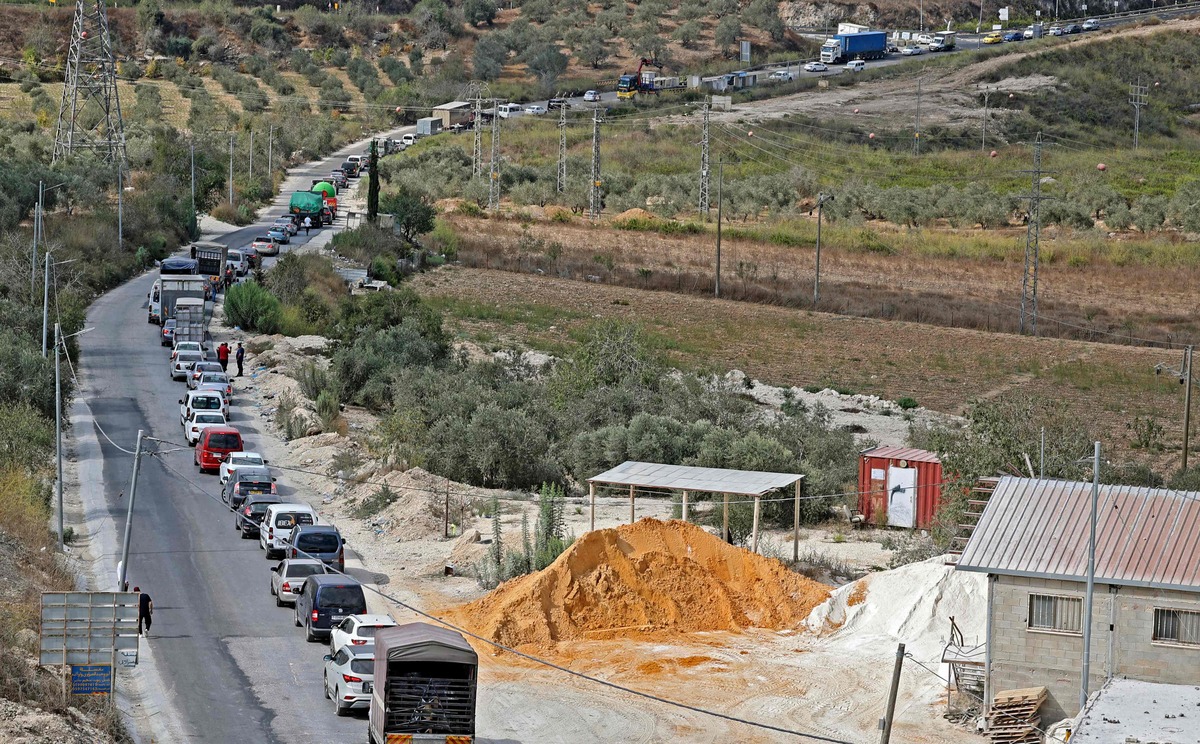 Cars line up as Palestinians try to enter the West Bank city of Nablus, through a checkpoint manned by Israeli security forces on October 13, 2022, two days after an Israeli soldier was shot and killed near a settlement in an attack claimed by Palestinian militants. (Photo by JAAFAR ASHTIYEH / AFP)