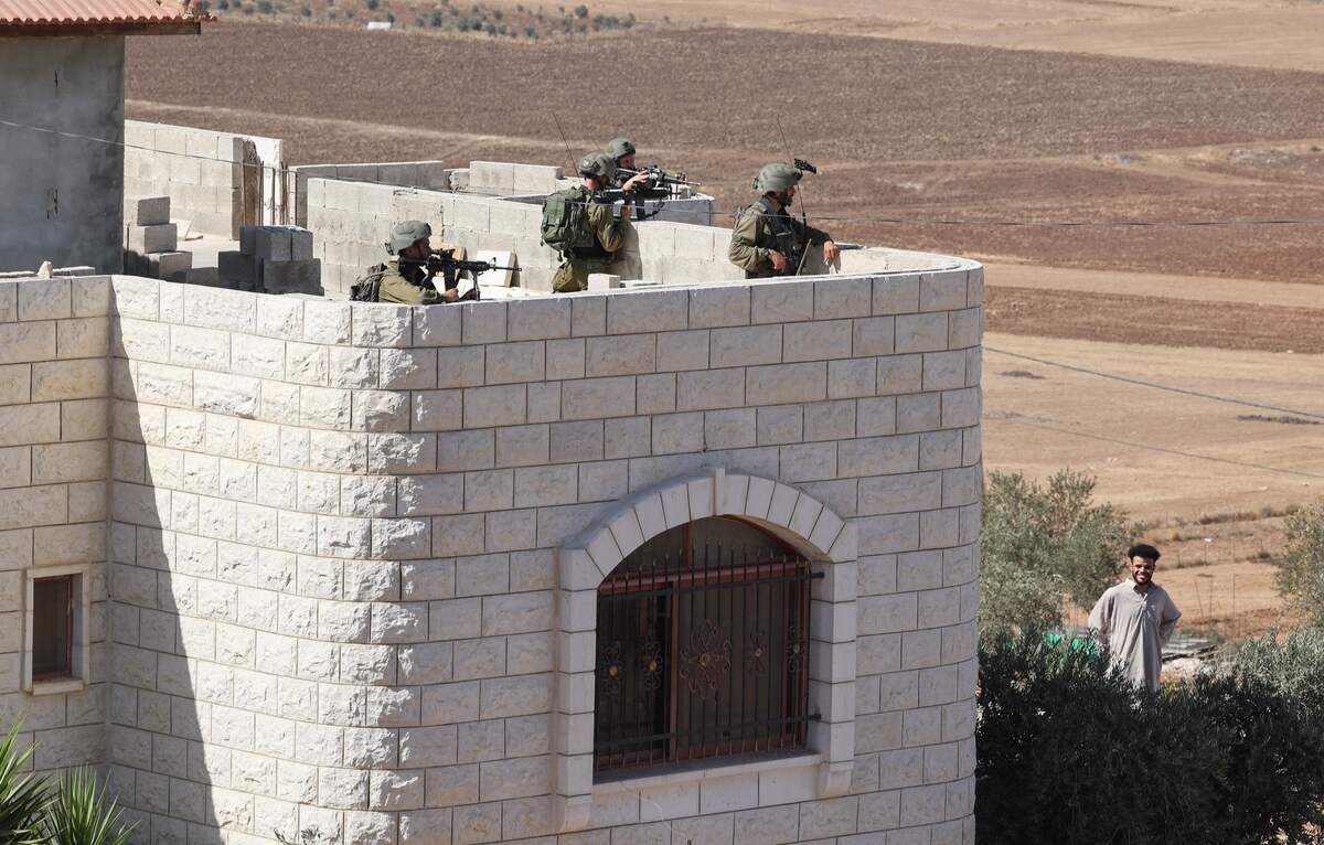 Members of Israeli security forces deploy on the roof of a house during a search in Salem town, east of Nablus city in the occupied West Bank, on Octobre 2, 2022, following reports of a shooting attack on a bus. (Photo by JAAFAR ASHTIYEH / AFP)