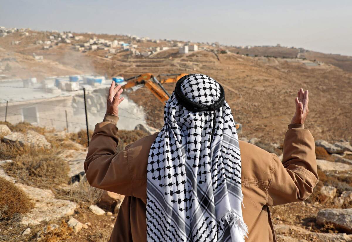 A man reacts as Israeli forces demolish a Palestinian-owned building in the West Bank village of Bani Naim on October 25, 2022. (Photo by MOSAB SHAWER / AFP)