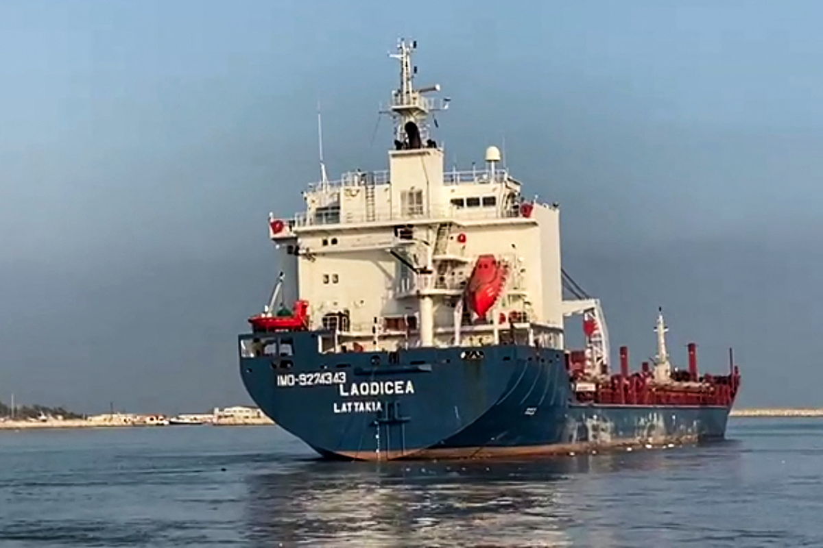 This picture taken on August 4, 2022 shows a view of the stern of the grain-laden Syrian-flagged cargo ship Laodicea as it is being towed by a tugboat in Lebanon's northern port of Tripoli. The Syrian ship left the port of Tripoli at 8:00 am (0500 GMT) on August 4 after it was cleared for release by Lebanon following its seizure over allegations it was carrying flour and barley stolen from Ukraine. Officials said that investigations failed to prove it carried stolen goods. It was later reported by authorities in Damascus to have arrived at the Syrian port of Tartous to unload its cargo. (Photo by Fathi AL-MASRI / AFP)