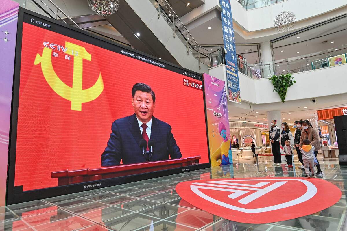 People watch a live broadcast of China's President Xi Jinping speaking during the introduction of the Communist Party of China's Politburo Standing Committee, on a screen at a shopping mall in Qingzhou in China's eastern Shandong province on October 23, 2022. China OUT (Photo by AFP)