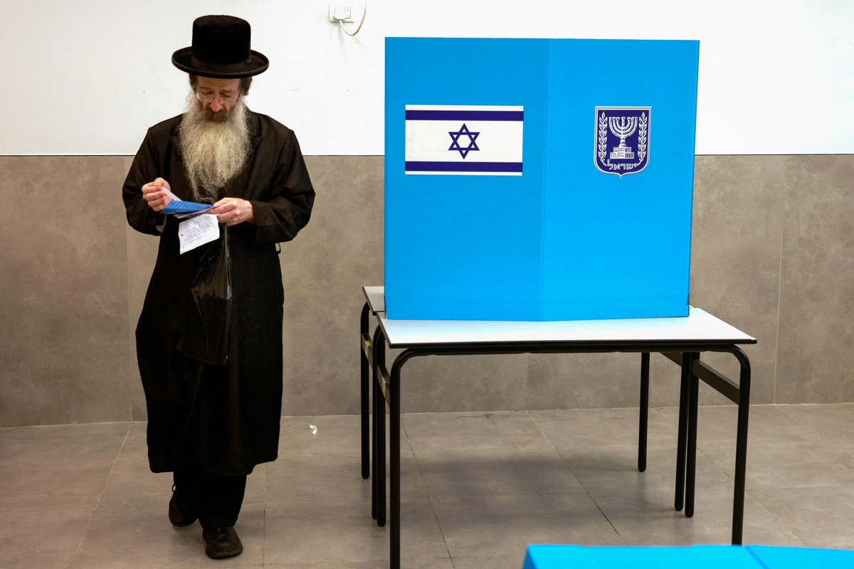 An ultra-Orthodox Jewish voter casts their ballot at a polling station in Bnei Brak, an Orthodox Jewish city near Tel Aviv, on November 1, 2022. Israelis began voting in their fifth election in less than four years, with veteran leader Benjamin Netanyahu campaigning for a comeback alongside far-right allies. (Photo by Menahem KAHANA / AFP)