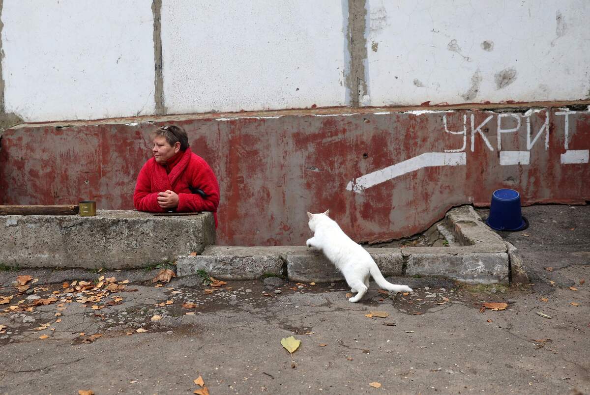 A local resident stands next to a shelter's entrance, in the basement of a residential building in Stepnohirsk on the east bank of the Dnipro River, south of Zaporizhzhia, on November 9, 2022, amid the Russian invasion of Ukraine. (Photo by Anatolii Stepanov / AFP)